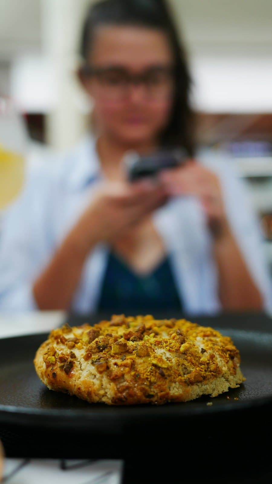 A warm pistachio cookie served on a dark plate at Bruttito