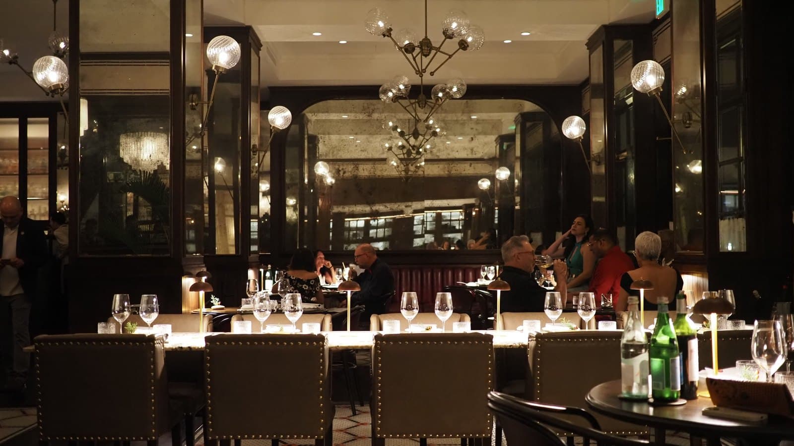 The dining room at Caleta in the Sofitel Legend, chandeliers above a long run of set tables