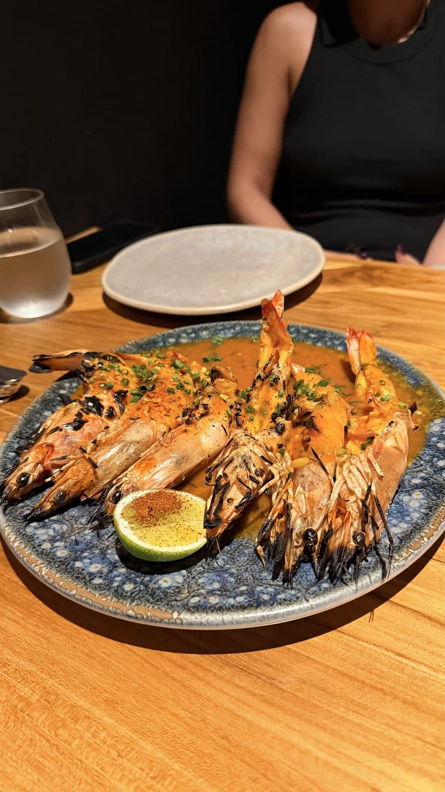 Grilled head-on prawns at Cantina del Tigre on a blue and white plate with a half lime