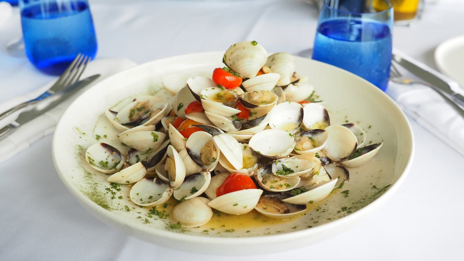 A plate of clams with cherry tomatoes and parsley at La Vespa Vista Mare