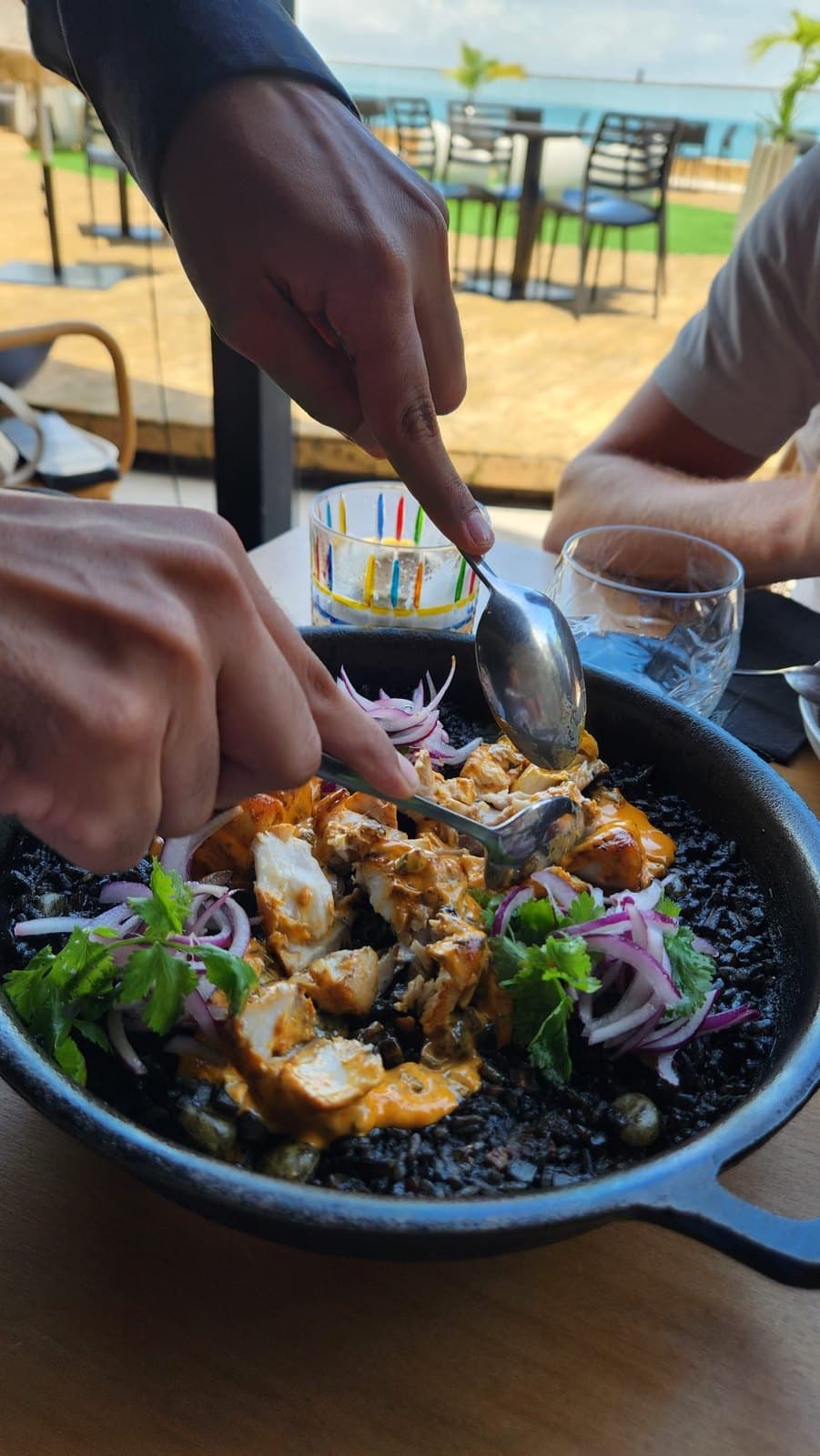 The arroz negro being mixed at the table at Lima Nikkei, served in a wide dark pan