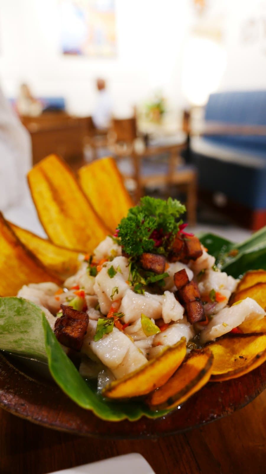 Fish ceviche at El Nacional with fried plantain slices on a wooden board