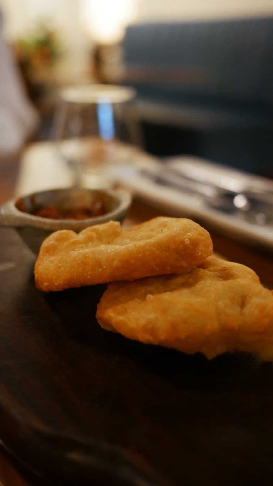 Golden fried dough rounds with a bowl of salsa, brought to the table at El Nacional before ordering