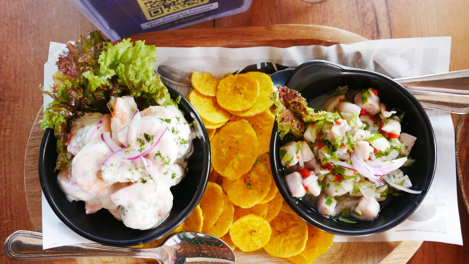 The duo ceviche at Sabroso: two black bowls of ceviche with fried plantain chips