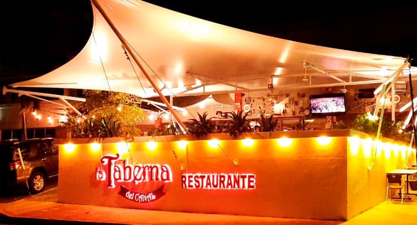 Open-air patio with white tensile canopy and string lights at La Taberna del Canal, Clayton, Panama City