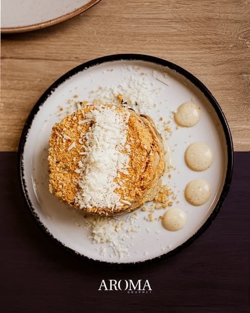 Crumb-crusted plated dish with grated cheese and cream sauce at Aroma Gourmet, Paitilla, Panama City