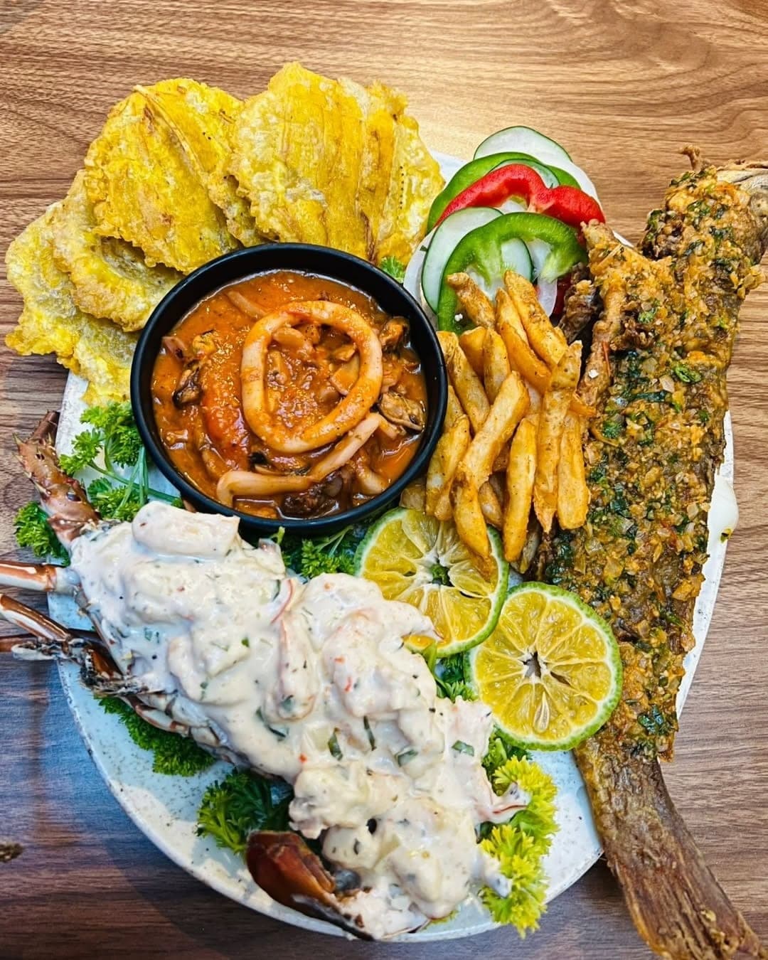 Overhead seafood platter with whole fried fish, lobster and patacones at Bocao507, Casco Viejo, Panama City