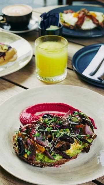Avocado and mushroom toast on beet puree with orange juice and cappuccino at Brew Coffee Company, San Francisco, Panama City