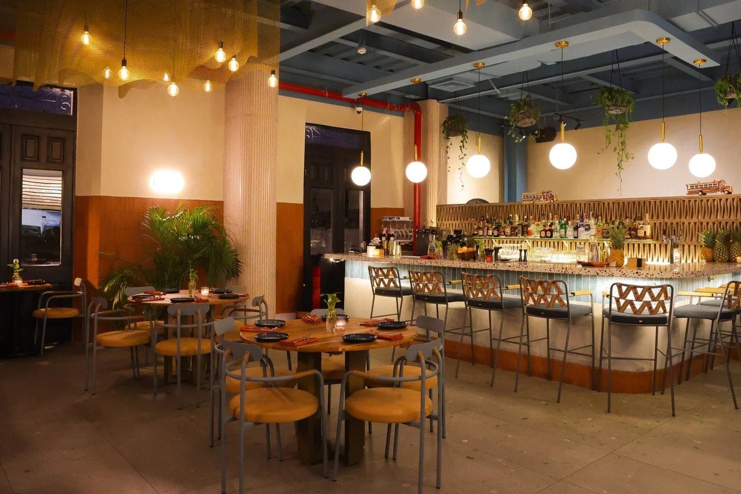 Interior dining room and bar with rattan stools and pendant lighting at Bruma Seafood & Wine, Casco Viejo, Panama City