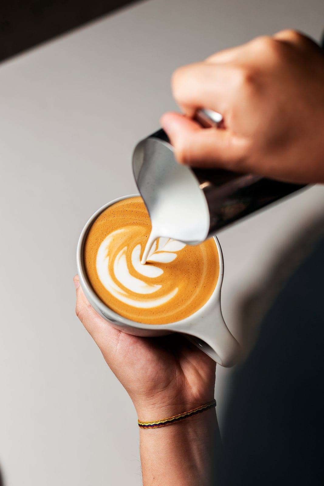 Barista vertiendo arte latte en una taza de Café Unido, Casco Viejo, Ciudad de Panamá