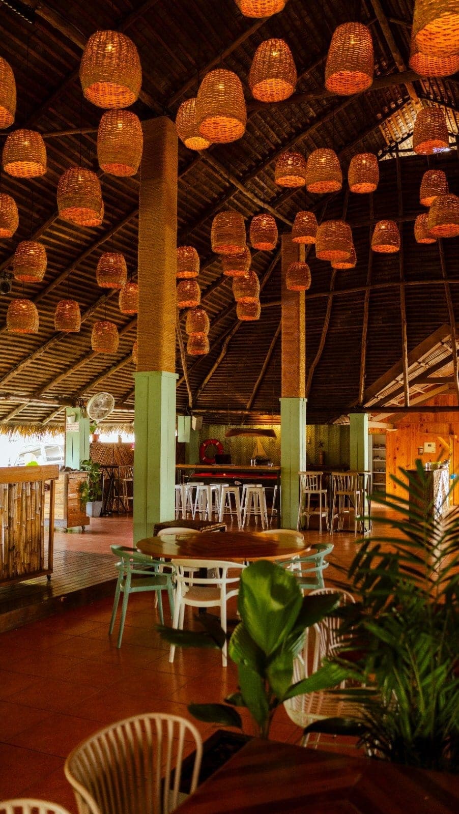 Woven rattan pendant lamps lighting the interior of Canal House, Amador, Panama City