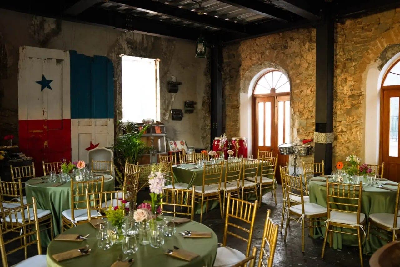Interior with exposed stone walls, colonial wooden doors and set tables at Casa Catedral, Casco Viejo, Panama City