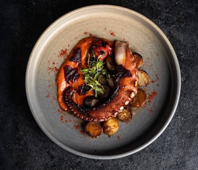 Grilled octopus with roasted potatoes on a stone plate at Catch Seafood & Grill, Casco Viejo, Panama City
