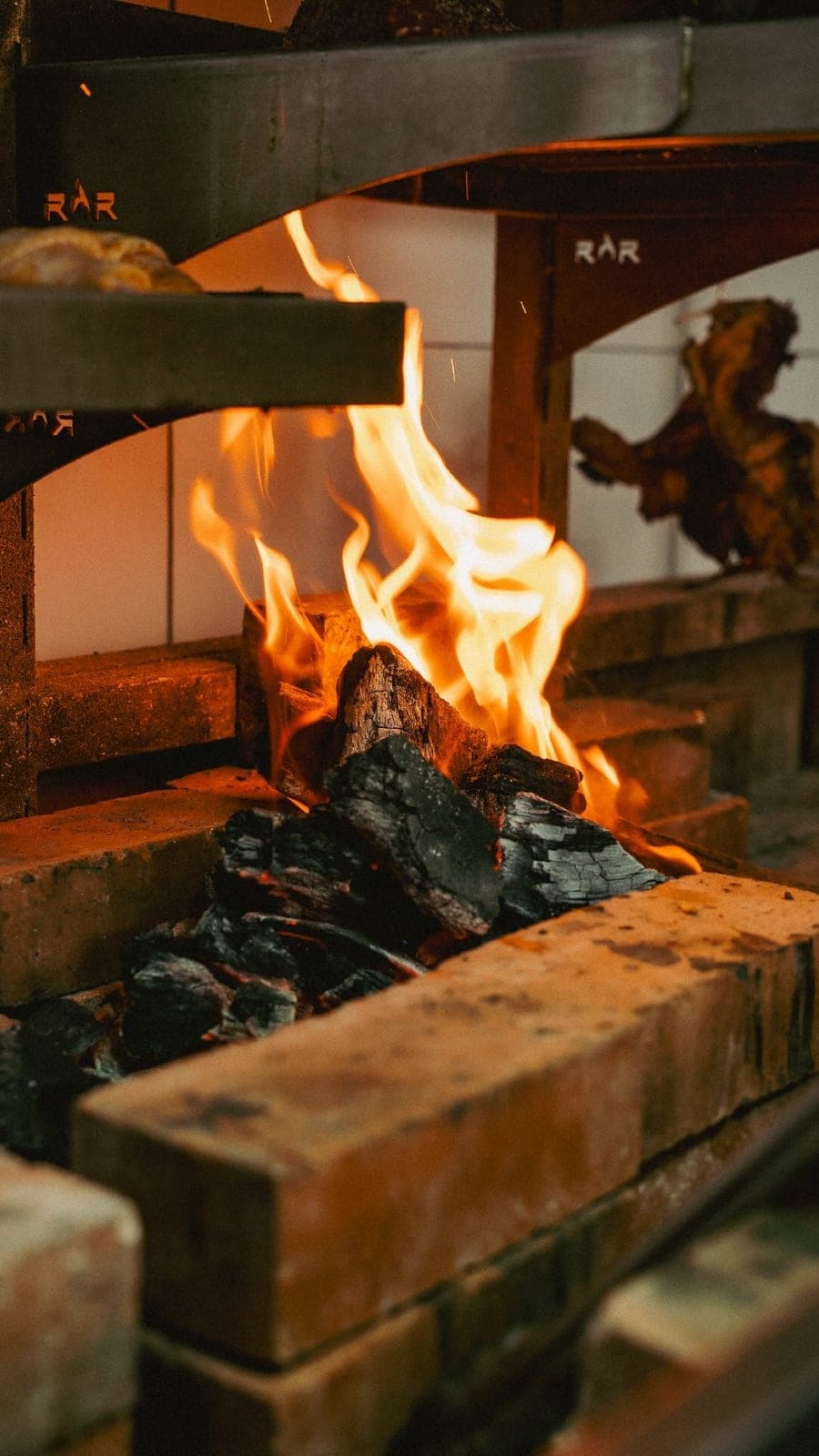 Open charcoal grill with flames at Igneo Restaurante, Panama City