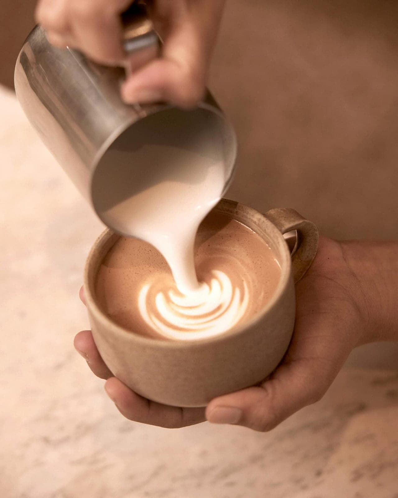 Barista pouring latte art at Krume Backer, Costa del Este, Panama City