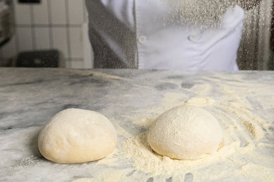 Two balls of freshly floured Roman pizza dough on a marble counter at Masa, Santa Ana, Panama City
