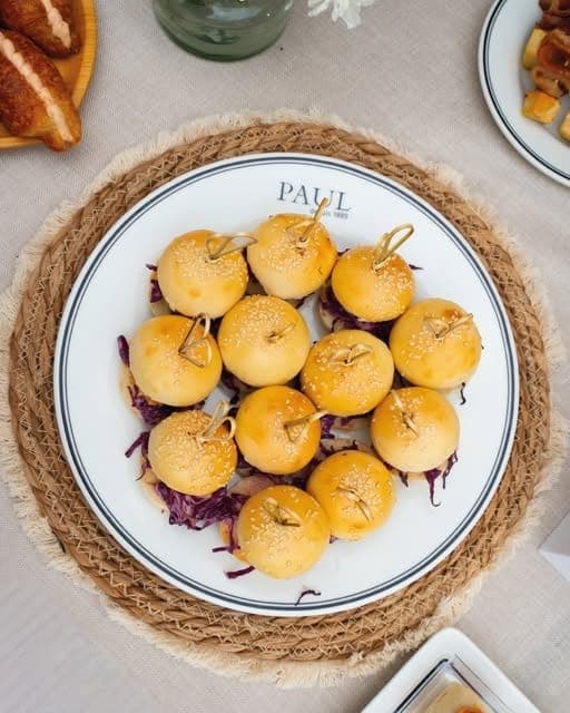 Plate of freshly baked mini brioche buns at PAUL Bakery & Restaurant, Marbella, Panama City