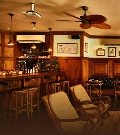 Wooden bar with a backlit bottle shelf and lounge seating at Pedro Mandinga Rum Bar, Casco Viejo, Panama City