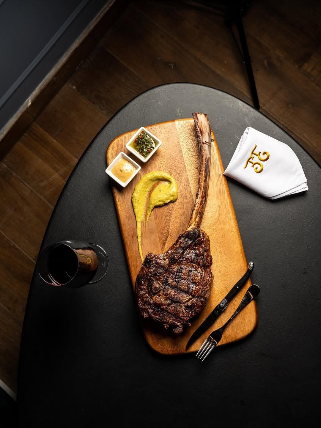 Grilled tomahawk ribeye on a wooden board with chimichurri at El Enemigo, Casco Viejo, Panama City
