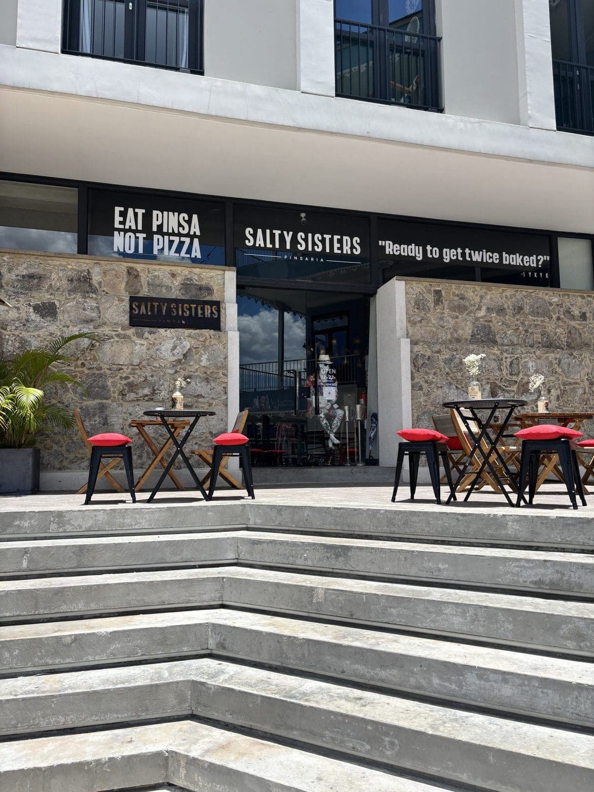 Fachada de piedra y patio de Salty Sisters Pinsaria, Casco Viejo, Ciudad de Panamá