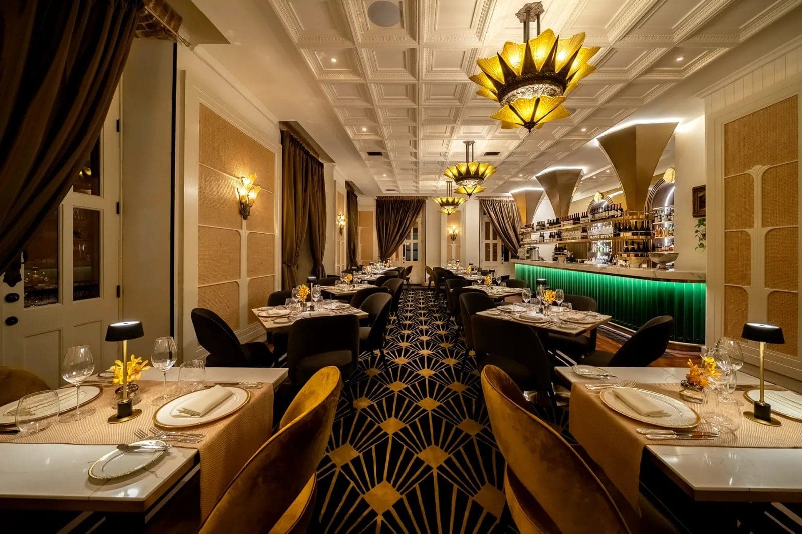 Art Deco dining room with set tables and starburst chandeliers at Villa Ana 1928, Casco Viejo, Panama City