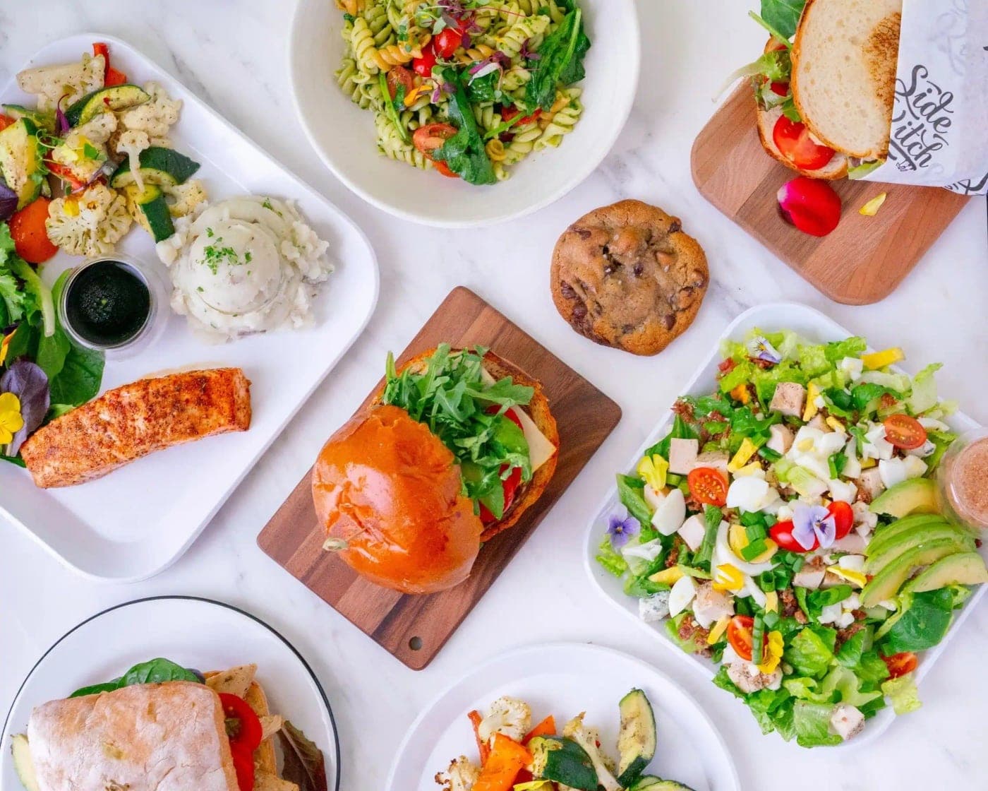 spread of salmon, burger and salads at WINGSTASTY, Panama City